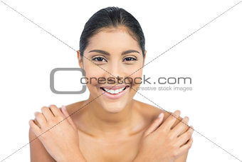Cheerful nude brunette holding shoulders