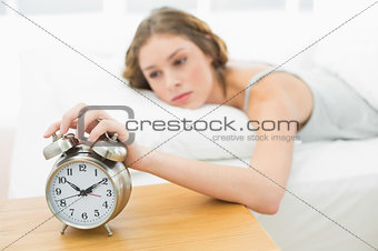 Beautiful woman waking up while lying in her bed