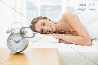Beautiful calm woman lying in her bed under the cover