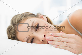 Peaceful tired woman lying in her bed yawning