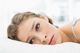 Tired woman lying in her bed looking irritated