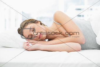 Attractive calm woman napping in her bed under the cover
