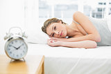 Attractive peaceful woman lying resting in her bed under the cover