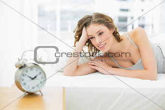 Content young woman lying in her bed under the cover