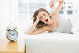 Yawning young woman lying in her bed