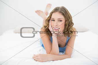 Cute young woman lying on her bed in her bed