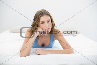 Relaxing calm woman lying on her bed leaning her head on her hand