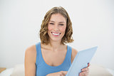 Gorgeous laughing woman holding her tablet while smiling at camera