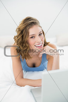 Lovely smiling woman using her notebook looking at camera