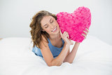 Content peaceful woman showing her pink heart pillow