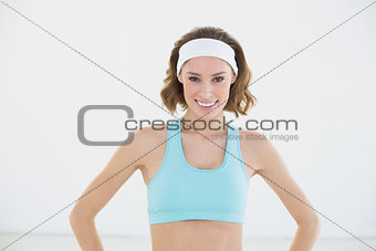 Lovely content woman posing with hands on hips smiling at camera
