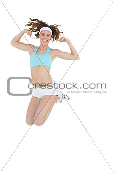 Sporty young woman jumping showing her arm muscles