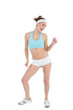 Happy ponytailed woman dancing wearing sportswear