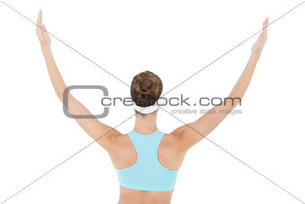 Rear view of slim brunette woman wearing sportswear raising her arms