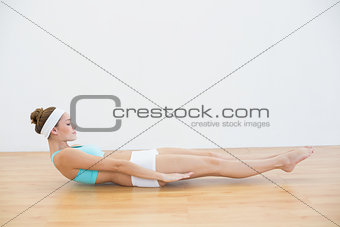 Attractive sporty woman doing sports exercise lying on the floor