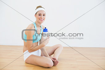 Attractive slim woman wearing sportswear sitting on the floor
