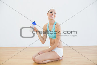 Young slim woman wearing sportswear holding sports bottle