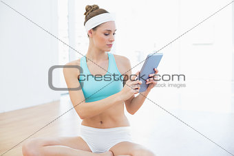 Lovely slender woman in sportswear using her tablet
