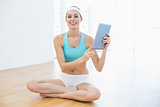 Cheerful slender woman holding her tablet looking at camera