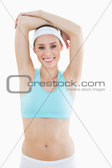 Content slim woman posing lifting her arms smiling at camera