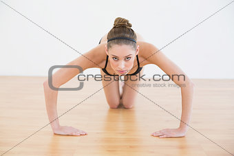 Cute sporty woman doing easy press ups looking at camera