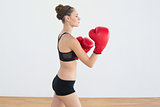 Pretty sporty woman wearing boxing gloves posing