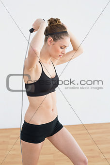 Focused toned woman skipping with rope