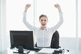 Beautiful cheering female businesswoman sitting at her desk