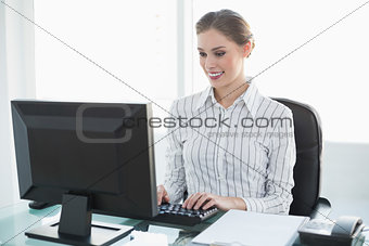 Happy chic businesswoman working on her computer