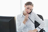 Serious chic businesswoman phoning with telephone