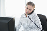 Focused chic businesswoman phoning with telephone