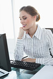Chic smiling businesswoman sitting at her desk