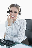 Gleeful female agent wearing headset sitting at her desk