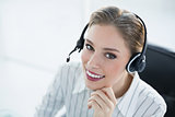 Beautiful smiling agent wearing headset sitting at her desk
