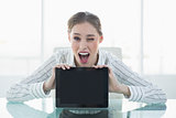 Beautiful happy businesswoman showing tablet blinking her eye