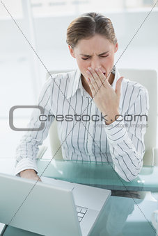 Exhausted attractive businesswoman working with her notebook