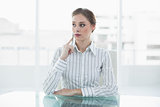 Serious young businesswoman sitting at her desk