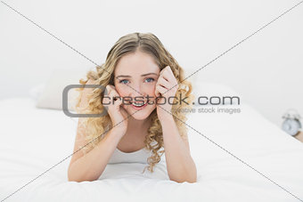 Pretty lucky blonde lying on bed looking at camera