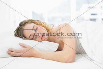 Pretty peaceful blonde lying in bed resting with closed eyes