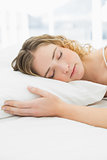 Pretty calm blonde lying in bed resting with closed eyes