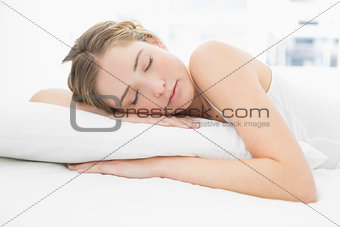Pretty calm blonde lying in bed sleeping peacefully