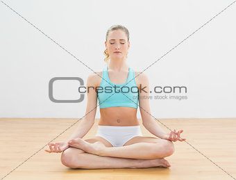 Peaceful slim blonde sitting in lotus pose