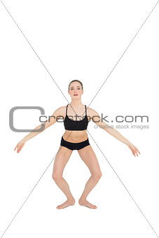 Focused slim ballet dancer jumping in the air