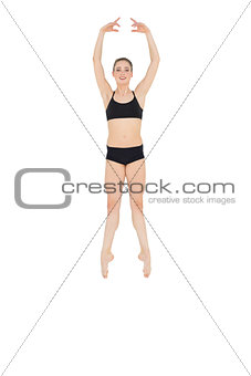Happy slim ballet dancer jumping in the air