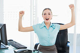 Classy cheerful businesswoman cheering with raised arms