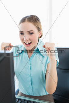 Classy happy businesswoman sitting in front of computer