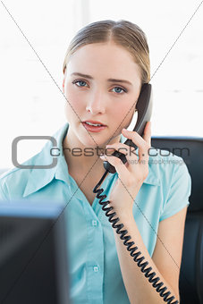 Classy unsmiling businesswoman phoning