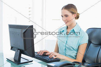 Classy happy businesswoman working at computer