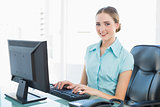 Classy smiling businesswoman working at computer