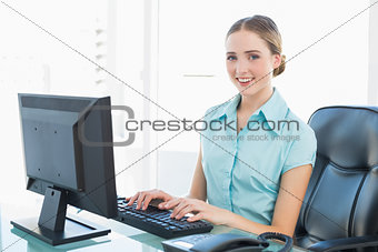 Classy smiling businesswoman working at computer